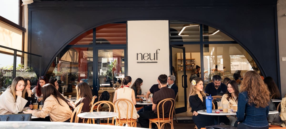 Neuf's shopfront in Bostanlı, with arched windows and full tables
